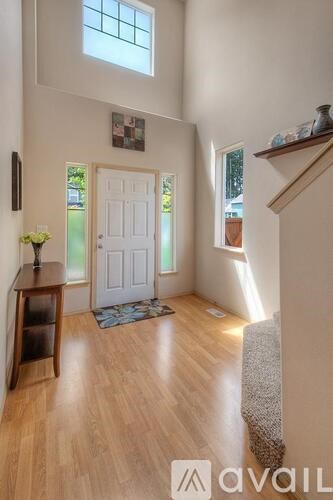 A hallway with a white door and a wooden floor.