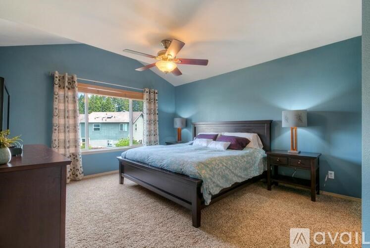 A bedroom with a bed, nightstand, and window.