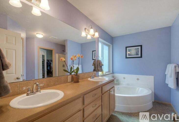 A bathroom with a white tub, sink, and a mirror.