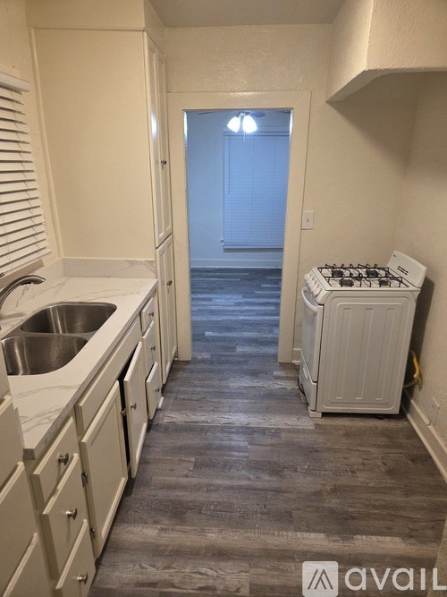 A kitchen with white cabinets and a stove top oven.