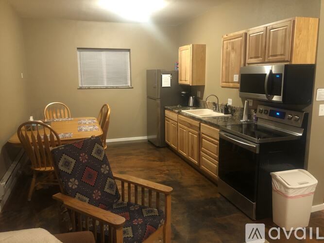 A kitchen with wooden cabinets and a dining table with chairs.