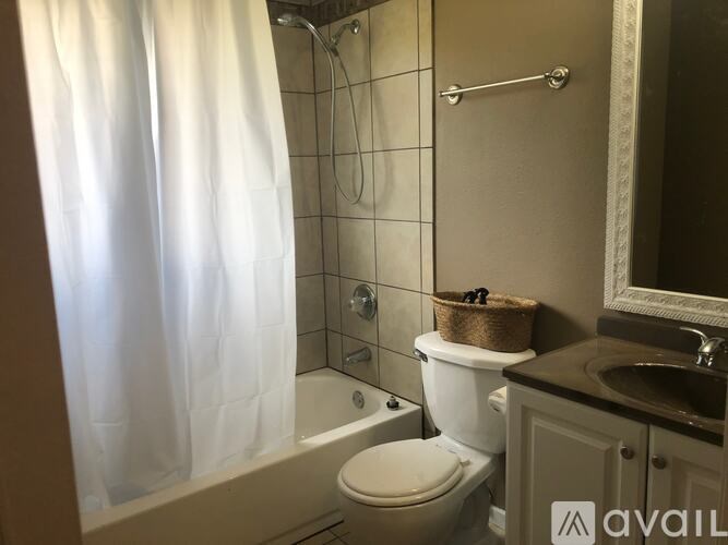 A bathroom with a toilet, sink, and shower.