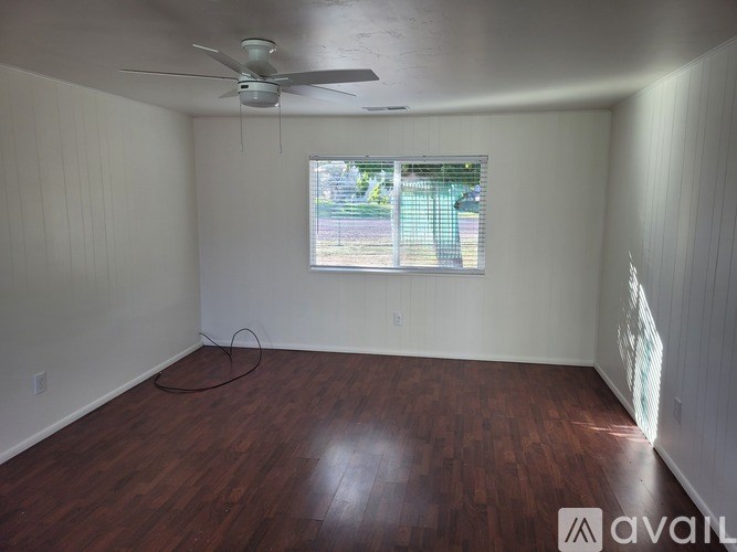 A room with a ceiling fan and a window.
