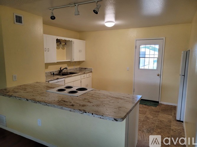 A kitchen with a granite countertop and white cabinets.