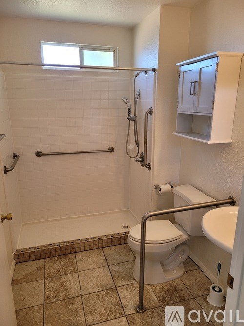 A bathroom with a toilet, sink, and shower.
