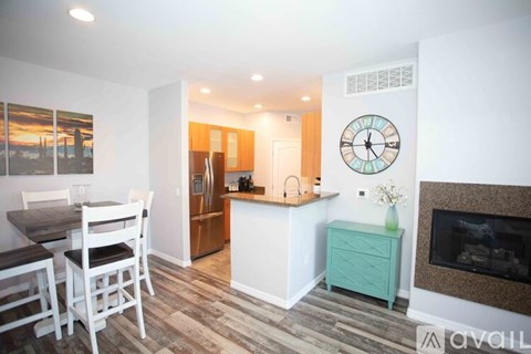 A kitchen with a table and chairs and a fireplace.