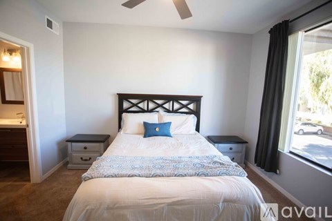 A bedroom with a large bed and a ceiling fan.