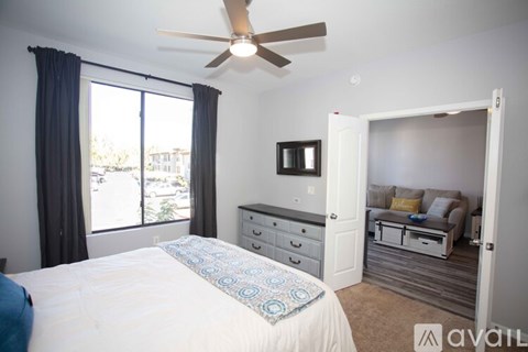 A bedroom with a bed, dresser, and a ceiling fan.