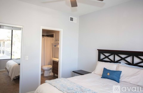 A bedroom with a bed, a toilet, and a window.