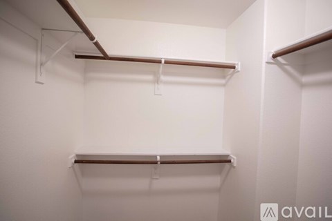 A white closet with two shelves and a hanging rod.