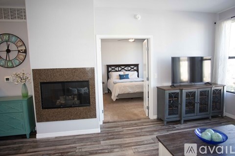 A living room with a fireplace, a bed, and a television.