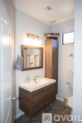 A bathroom with a sink, mirror, and toilet.