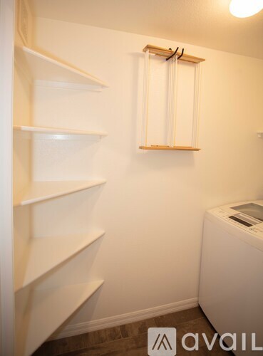 A small room with a window and a washing machine.