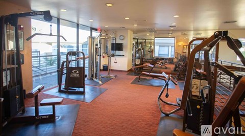 A gym with a variety of equipment including treadmills, weights, and exercise machines.