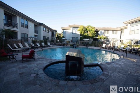 A pool surrounded by chairs and buildings.