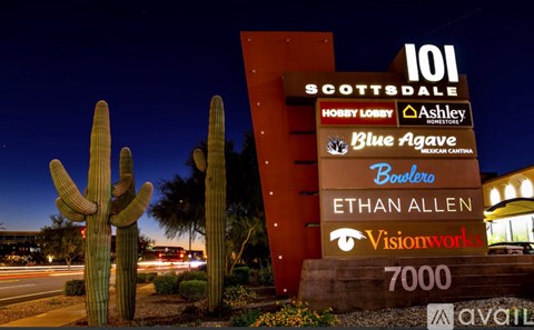 A sign for a housing development called Scottsdale is displayed at night.