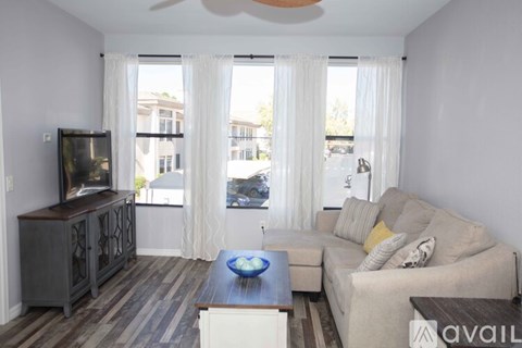 A living room with a television, couch, and a coffee table.