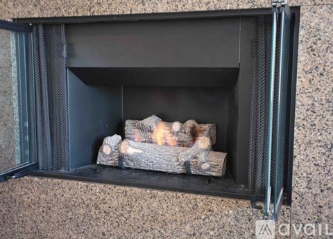A fireplace with logs burning inside.
