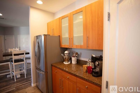 A kitchen with wooden cabinets and a refrigerator.