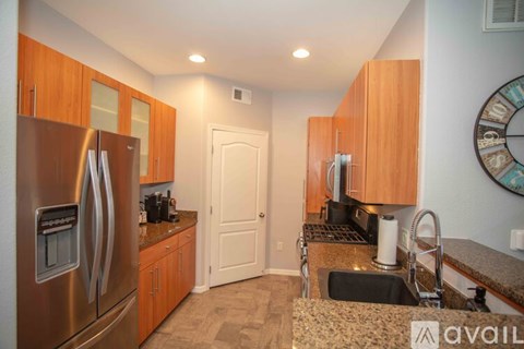 A kitchen with wooden cabinets and a stainless steel refrigerator.
