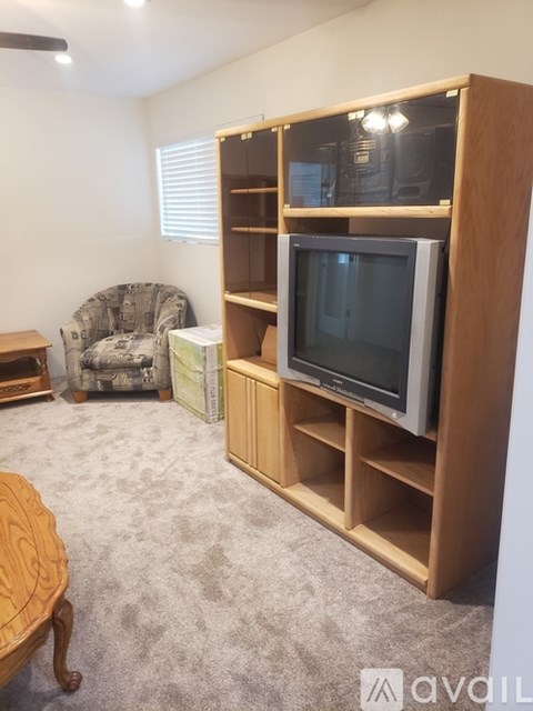 A living room with a television and a chair.