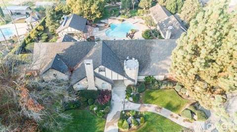 A large house with a swimming pool surrounded by trees.