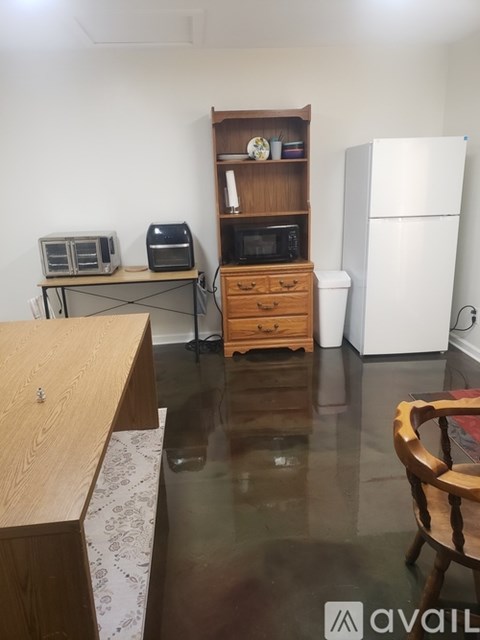 A kitchen with a white fridge, microwave, and toaster oven.