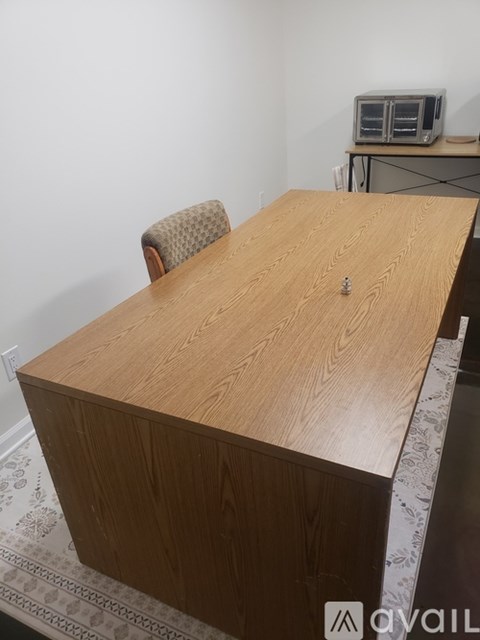 A wooden table with a chair in front of it.