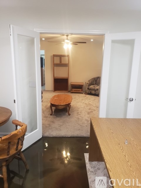 A room with a wooden table and a rug in the middle.