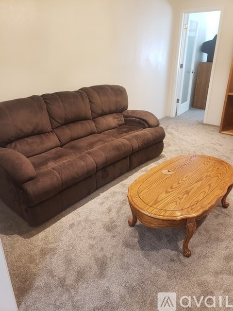 A brown sofa and wooden coffee table in a room.