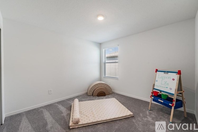 A room with a white wall and a Lagoon Life mattress on the floor.