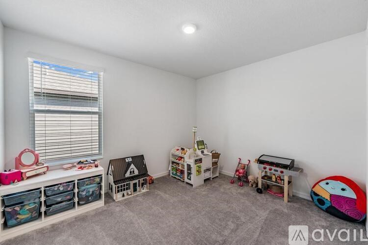 A child's playroom with toys and a dollhouse.