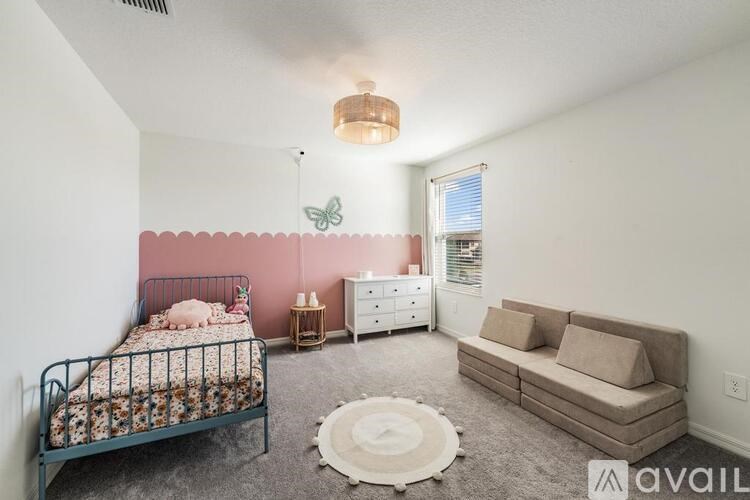 A bedroom with a bed, dresser, and couch.