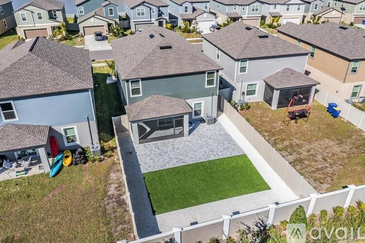 A bird's eye view of a residential area with houses and a green lawn.