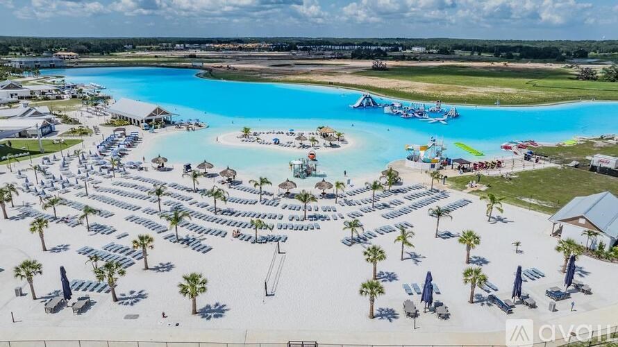 A large outdoor swimming pool surrounded by sun loungers and umbrellas.
