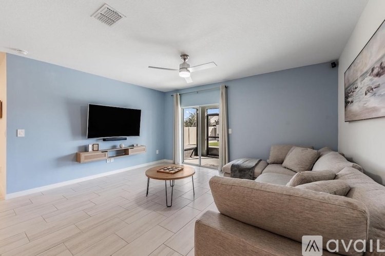 A living room with a television, a couch, and a coffee table.