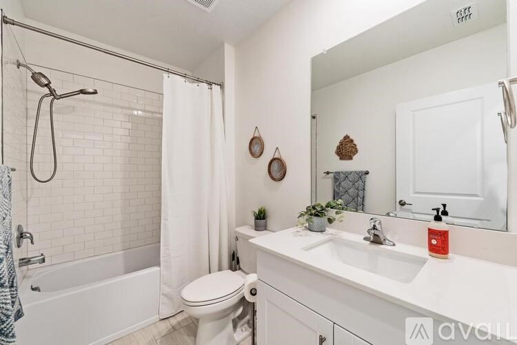 A white bathroom with a toilet, sink, and shower.
