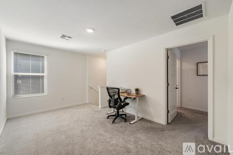 A room with a desk and a chair in it.