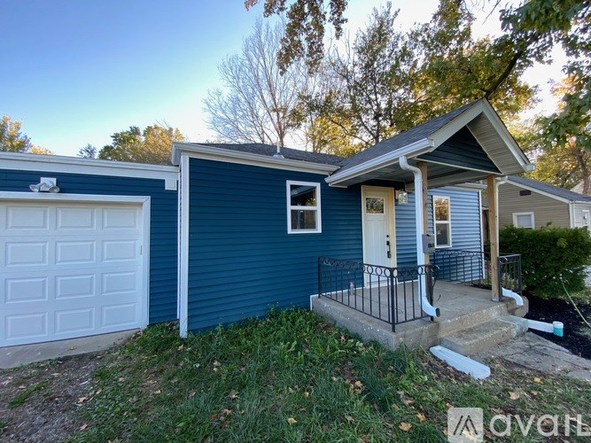 A blue house with a white garage door and a small porch.