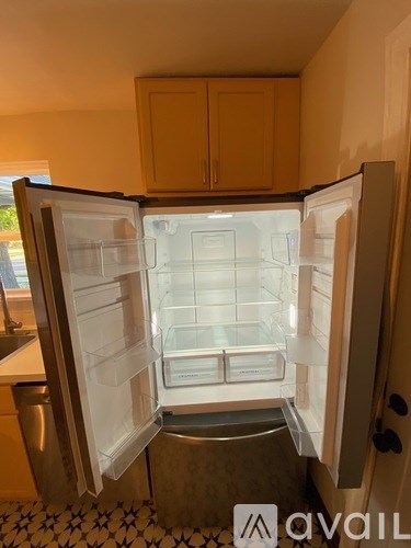 A white refrigerator with its door open in a kitchen.