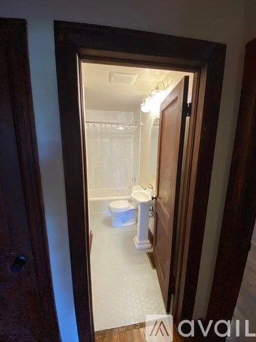 A bathroom with a toilet and sink is visible through an open door.