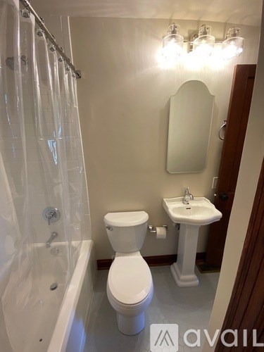 A white toilet sits next to a white sink in a bathroom.