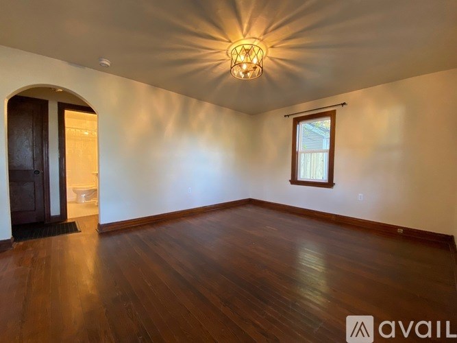 A room with wooden floors and a chandelier.