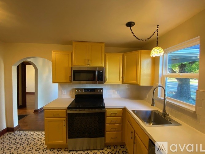 A kitchen with wooden cabinets and a black stove top oven.