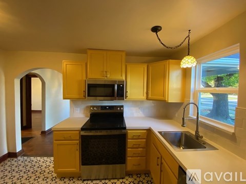 A kitchen with wooden cabinets and a black stove top oven.