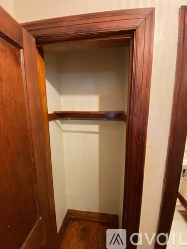 A wooden wardrobe with a mirrored shelf is open.