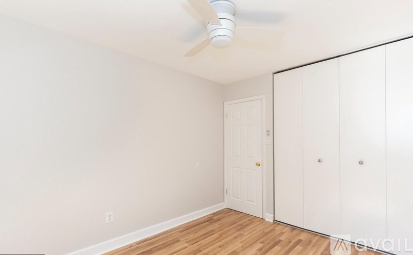 A room with a ceiling fan and a door.