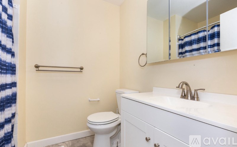 A bathroom with a toilet, sink, and mirror.
