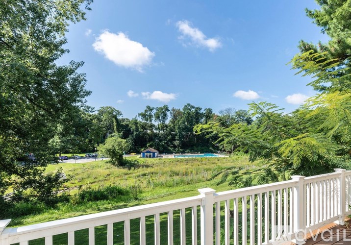 A white fence borders a lush green landscape.