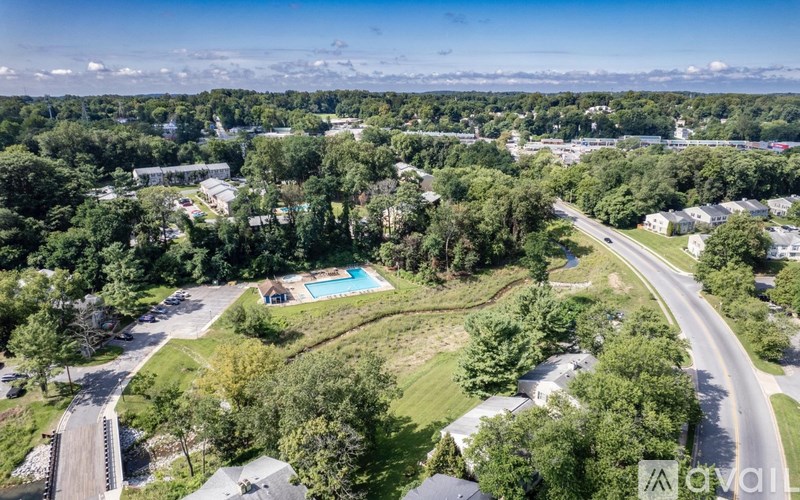 An aerial view of a residential area with a swimming pool and trees.